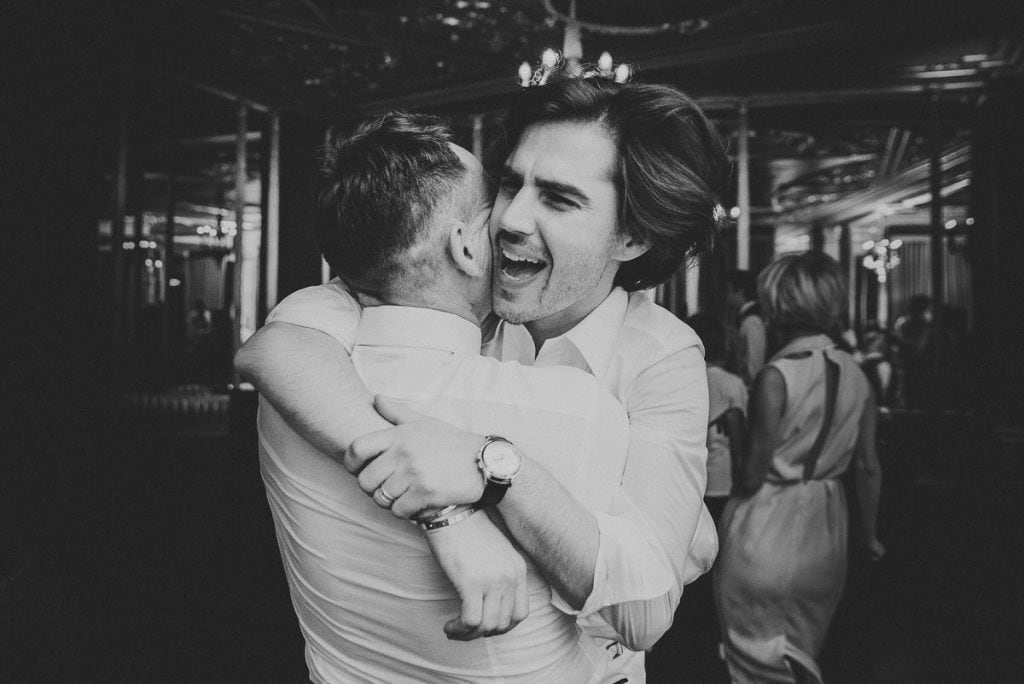 Two men hugging each other at a party.
