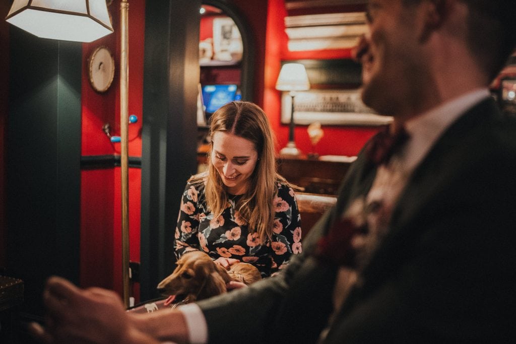 wedding guest with miniature dachsund on her lap