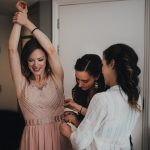 bridesmaid being helped with her dress