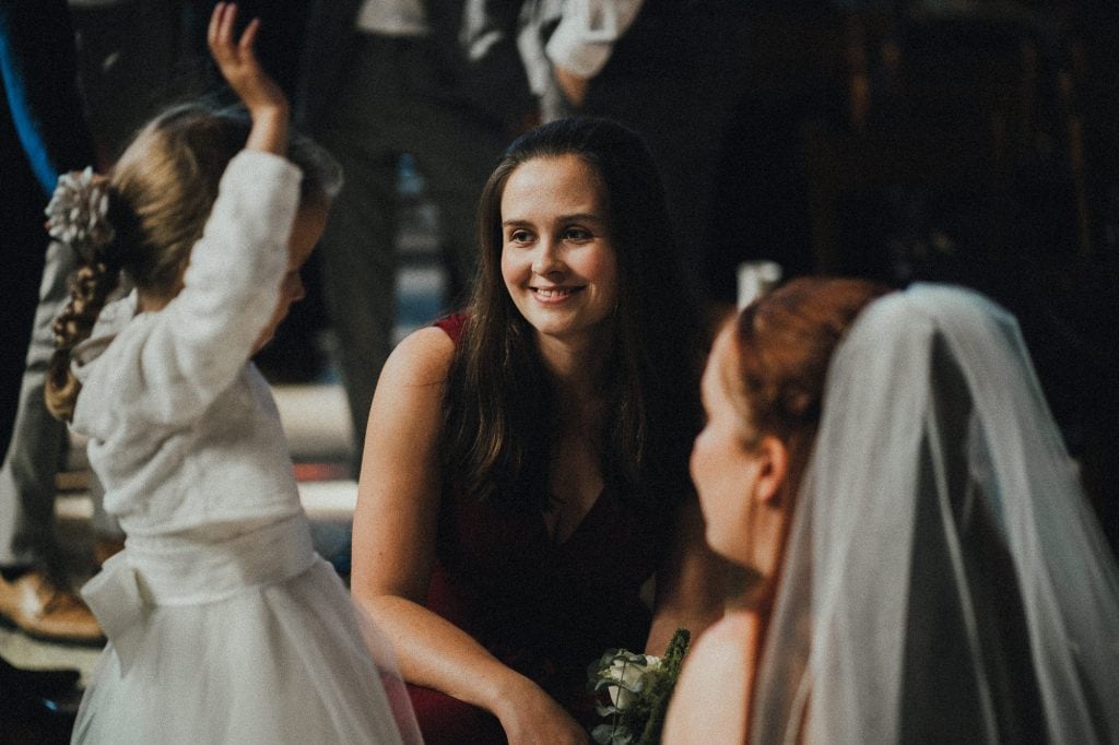 bridesmaid smiles at flower girl