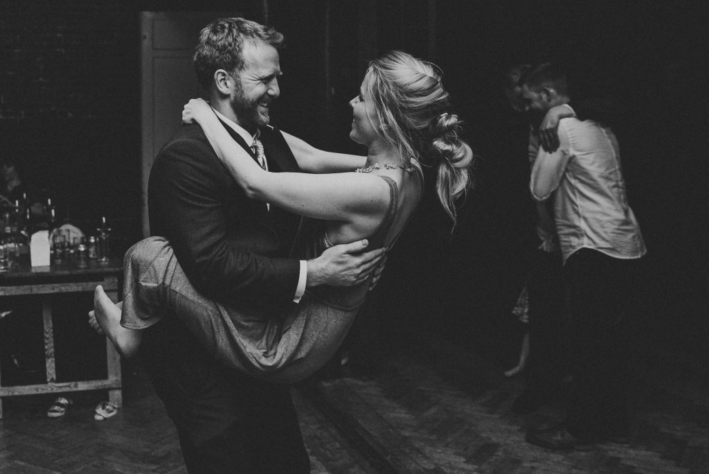 man lifting his girlfriend up on dance-floor