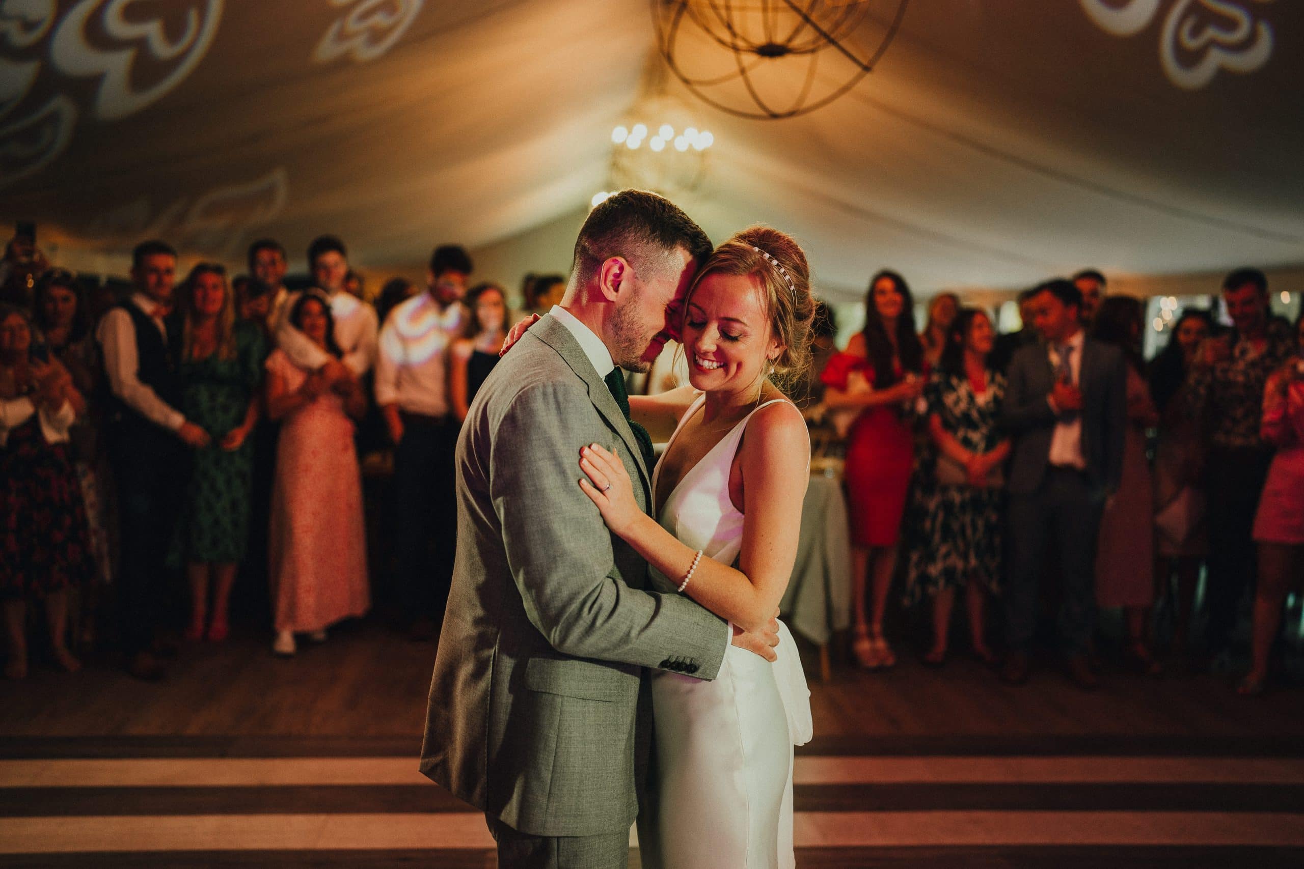 A bride and groom sharing their first dance in a tent.