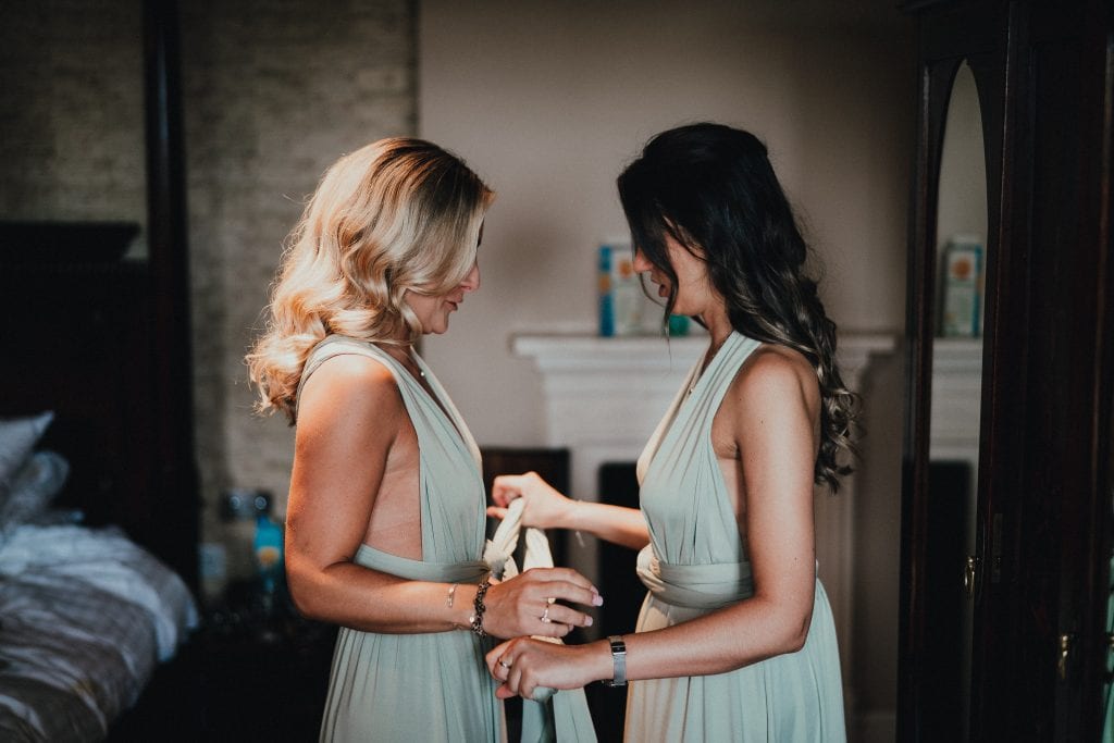 bridesmaids tying dress