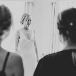 the bride as her bridesmaids see her in her dress for the first time