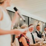 groom and best man reacting to bride's speech