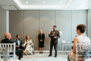 Wedding ceremony with officiant speaking to bride and groom.