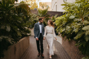 Couple walking in city garden alley.