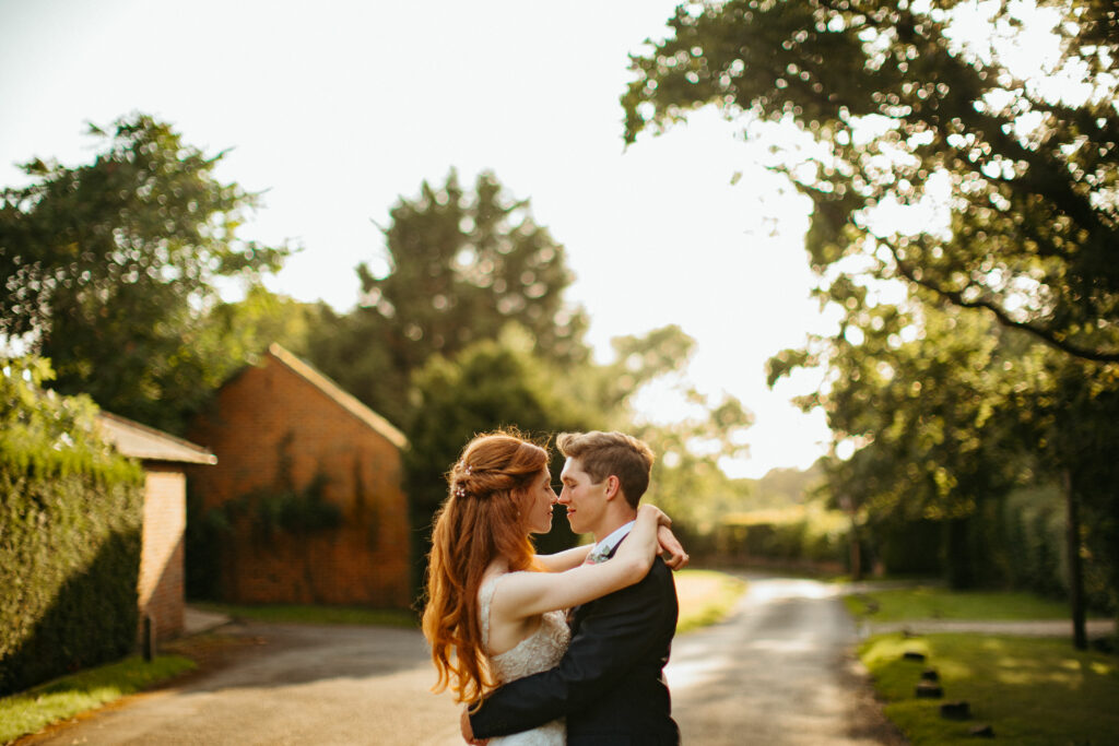 Couple embracing on a sunlit pathway.