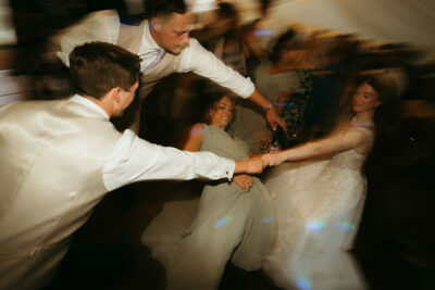 Joyful wedding guests dancing in a blur effect.