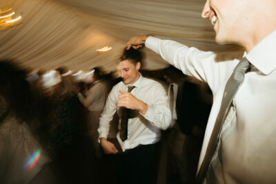Men dancing at lively evening wedding reception.