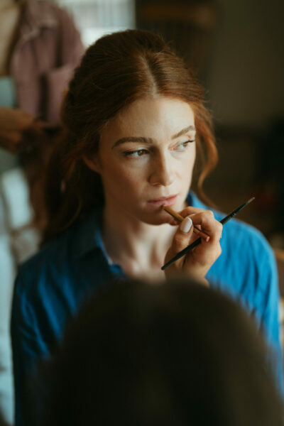 Woman having makeup applied by makeup artist.