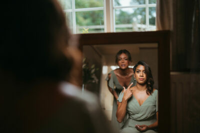 Woman applying makeup in mirror reflection.