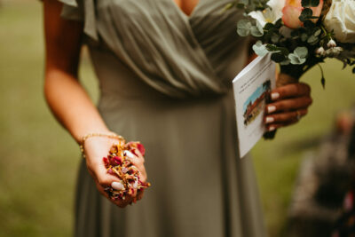 Bridesmaid holding petals and program at wedding