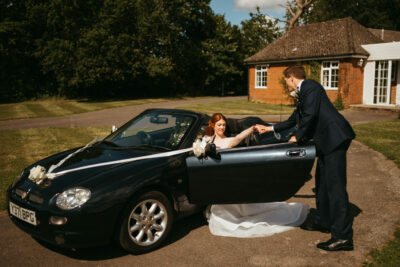 Bride and groom with wedding car.
