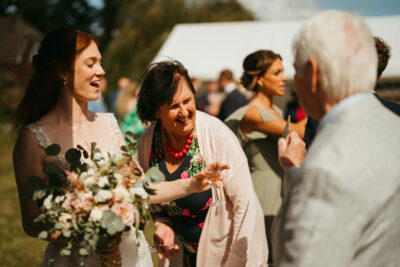 Bride laughing at sunny outdoor wedding ceremony