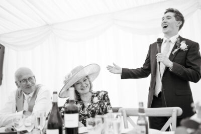 Groom giving speech at wedding reception.