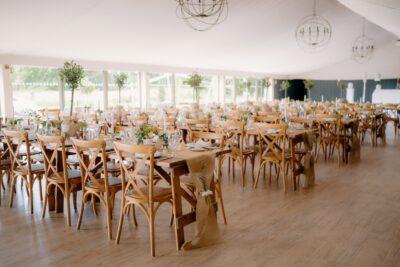 Elegant wedding reception hall with wooden chairs.