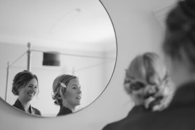 Women smiling in mirror reflection, preparing hair