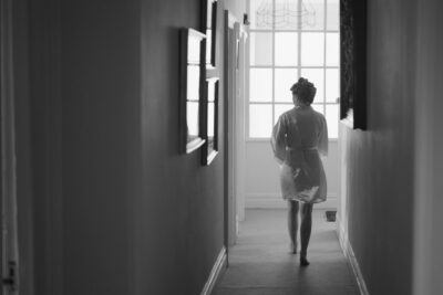 Person in robe walking through bright hallway