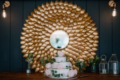 Floral wedding cake with gold decorative mirror