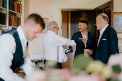 Group of men talking and shaking hands indoors.