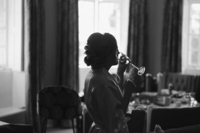 Silhouette of woman drinking champagne indoors.