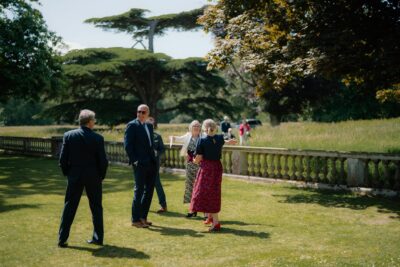 People conversing at an outdoor garden event.