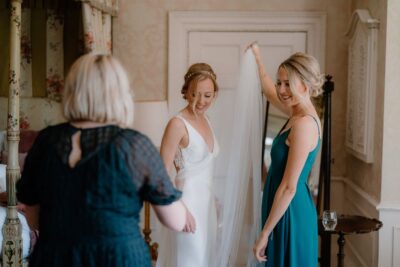 Bride getting ready with friends before wedding ceremony.