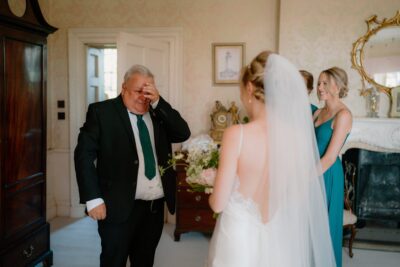 Father sees bride for the first time, emotional moment.