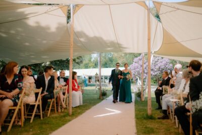 Outdoor wedding ceremony with guests seated.