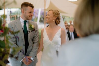 Bride and groom smiling at wedding ceremony.