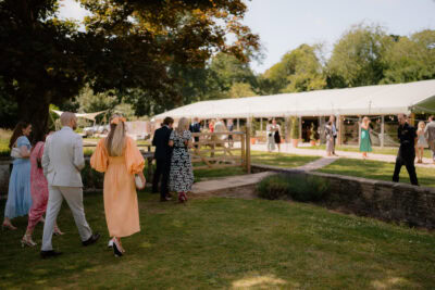 Guests walking towards outdoor wedding reception tent.
