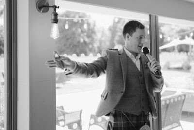 Man giving speech with microphone indoors.