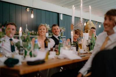 Guests smiling at a wedding reception table.
