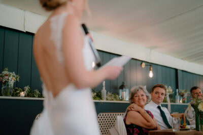Wedding speech, guests smiling and listening.