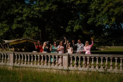 Group celebrating outside with drinks, sunny day.