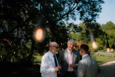 Three men talking at a garden party