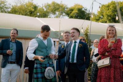 Guests celebrating at outdoor wedding reception.