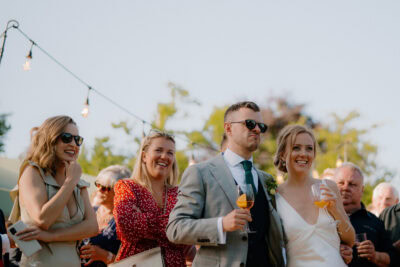 Group of people celebrating outdoors with drinks.