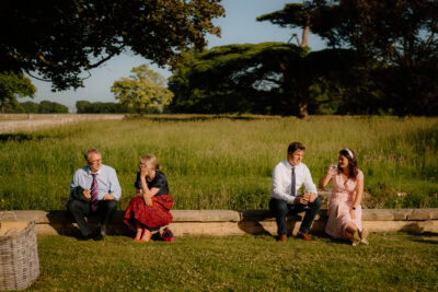 Group sitting on a garden wall, enjoying sunlight.