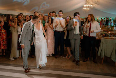 Newlyweds dancing at lively wedding reception.