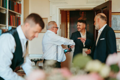 Men conversing happily at an indoor event.