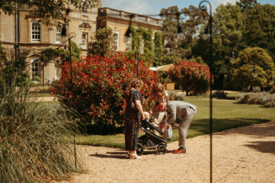 Family enjoying a sunny day at stately home garden.