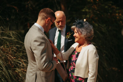 Groom and mother at outdoor wedding ceremony.