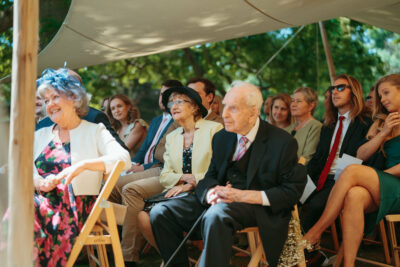 Guests seated at outdoor wedding ceremony.