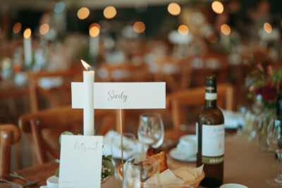 Elegant table setting with 'Sicily' sign and lit candle.