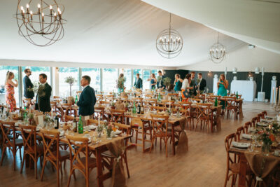 Elegant wedding reception inside marquee with guests.