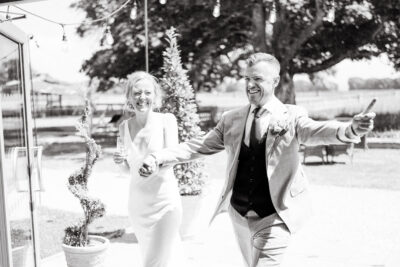 Joyful couple celebrating at wedding outdoors.