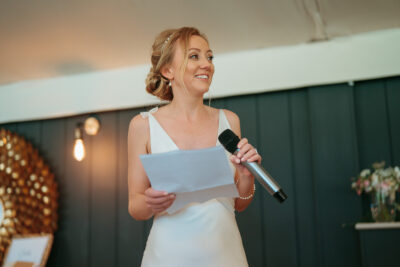 Woman giving speech at event with microphone.