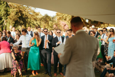 Guests laughing at outdoor wedding ceremony.